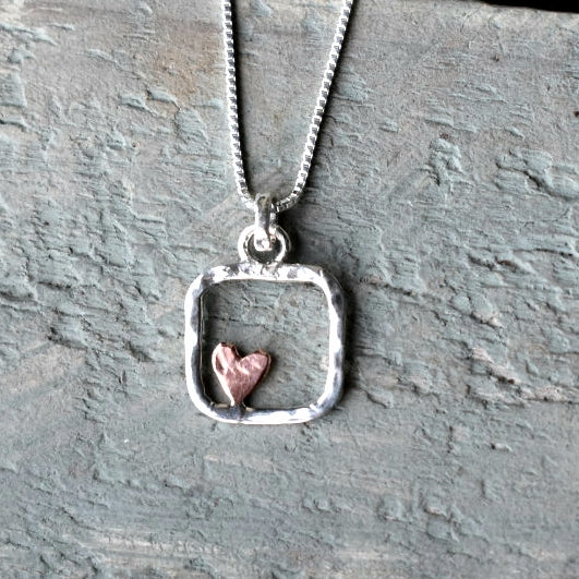 Textured silver open square, 15mm x 15mm, with a small copper heart inside.

Please note all pieces are made on order by Erfdeel Juwele. Allow up to a week for manufacture.

