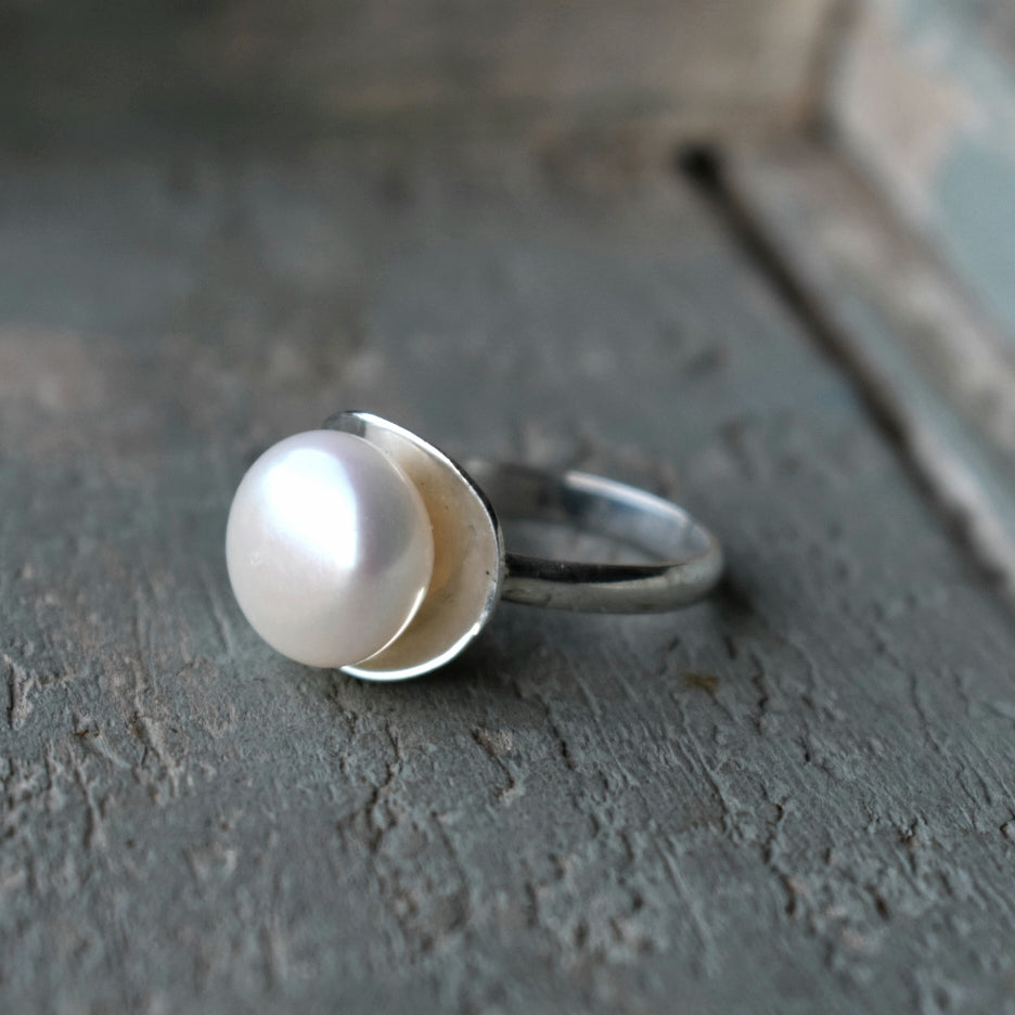 10mm Freshwater pearl in a concave silver cup with a 3mm D-shape band.

Please note all pieces are made on order by Erfdeel Juwele. Allow up to two weeks for manufacture. 

