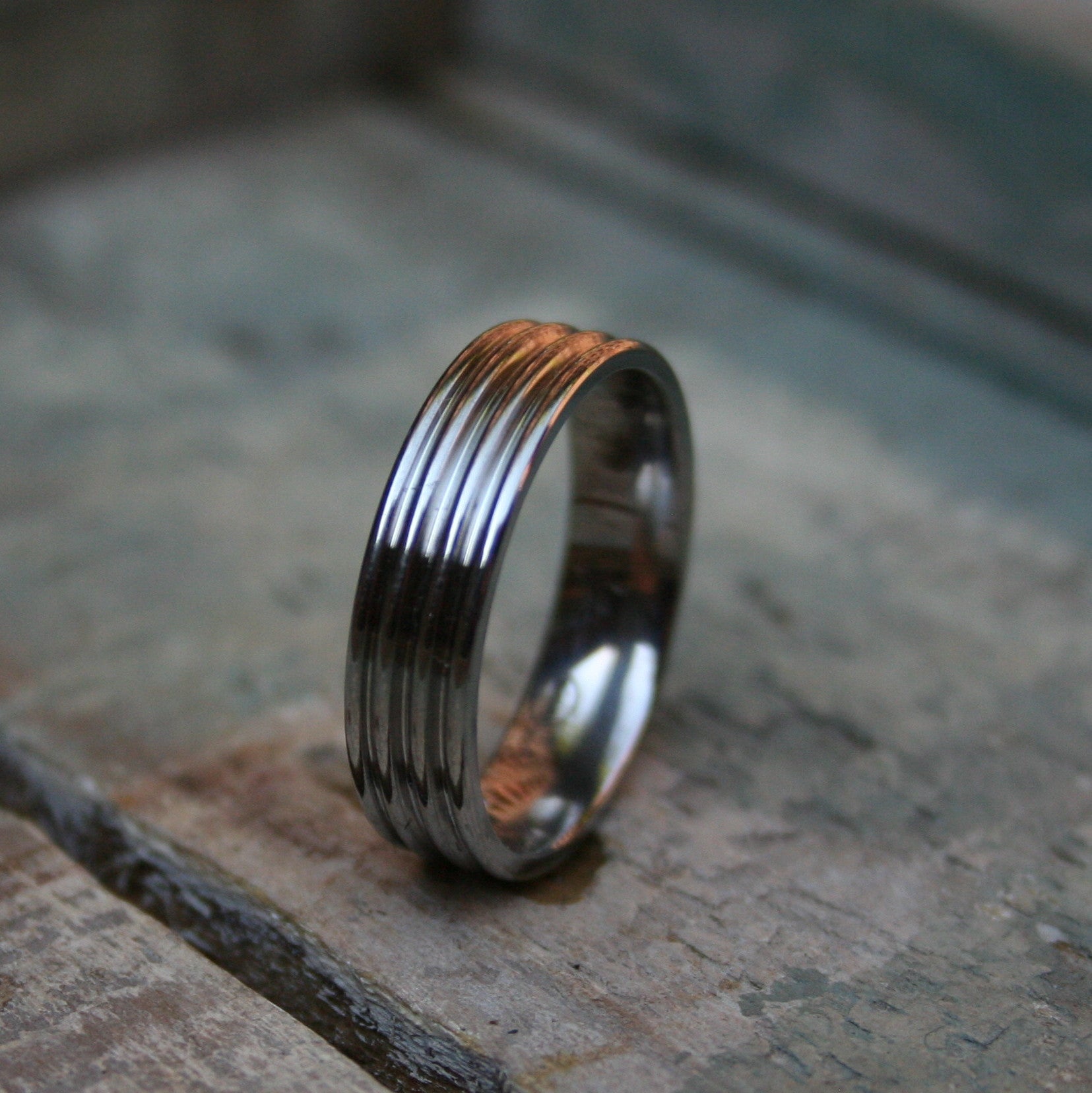 6mm Titanium with three grooves cut in. The ring is made with a comfort fit on the inside and a polished finish.