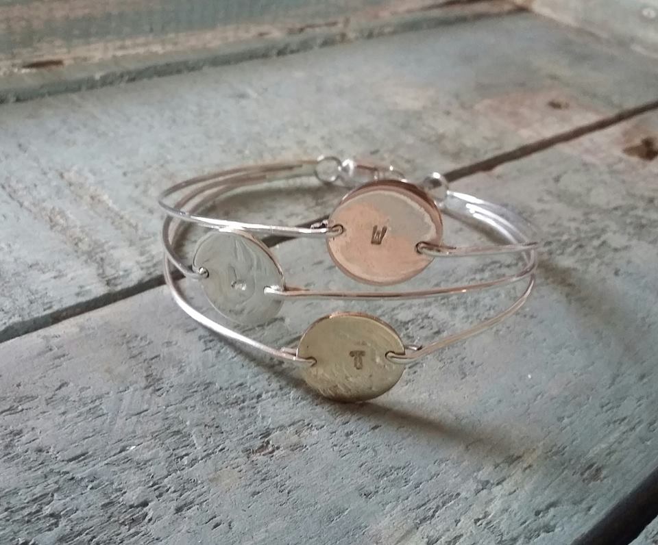 A sterling silver bangle with three 10 mm discs (silver, rose and yellow gold) on 1.5mm wire.