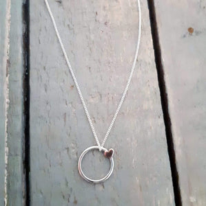 15 mm silver ring made from 1.2mm bar with a small copper heart soldered on. The pendant is sold with a 45 / 50 /55 cm curb chain.

Please note all pieces are made on order by Erfdeel Juwele. Allow up to two weeks for manufacture when placing an order.

