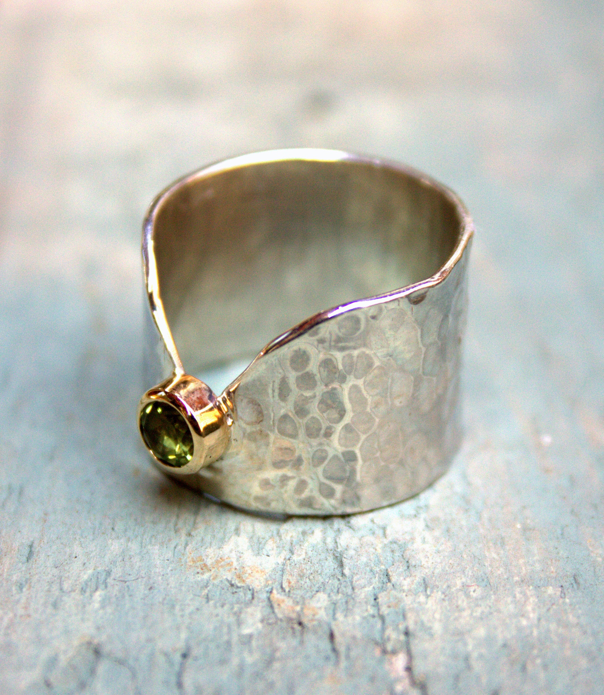 Silver band with peridot set in yellow gold