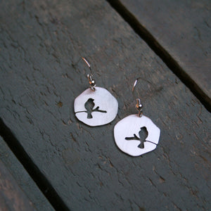 Sterling silver free form discs with a hand pierced silhouette of a bird sitting on a branch. Available with a matt or polished finish  Please note all pieces are handmade on order by Erfdeel Juwele. Allow up to two weeks for manufacture.