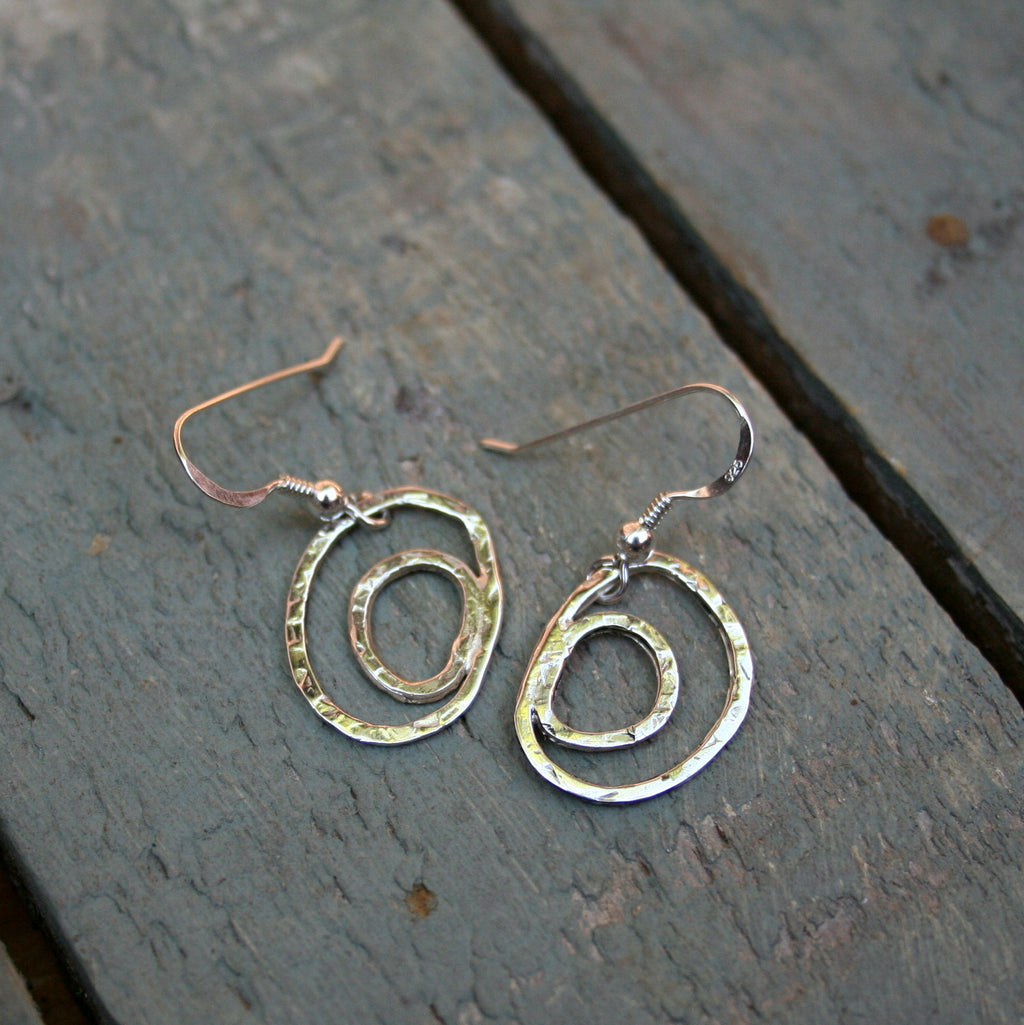 Two free from rings, one inside the other made from sterling silver with a hammered texture on sterling silver hooks.  Please note all pieces are handmade on order by Erfdeel Juwele. Allow up to two weeks for manufacture.